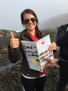 María Pirner at brach with sea star attached to guide book
